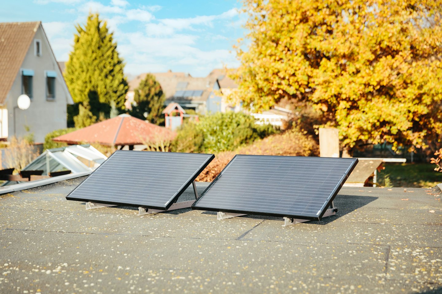 Dos paneles solares en un tejado bajo un sol brillante.